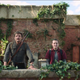 Joel and Ellie stand looking out on a balcony in a moment from HBO's The Last of Us.